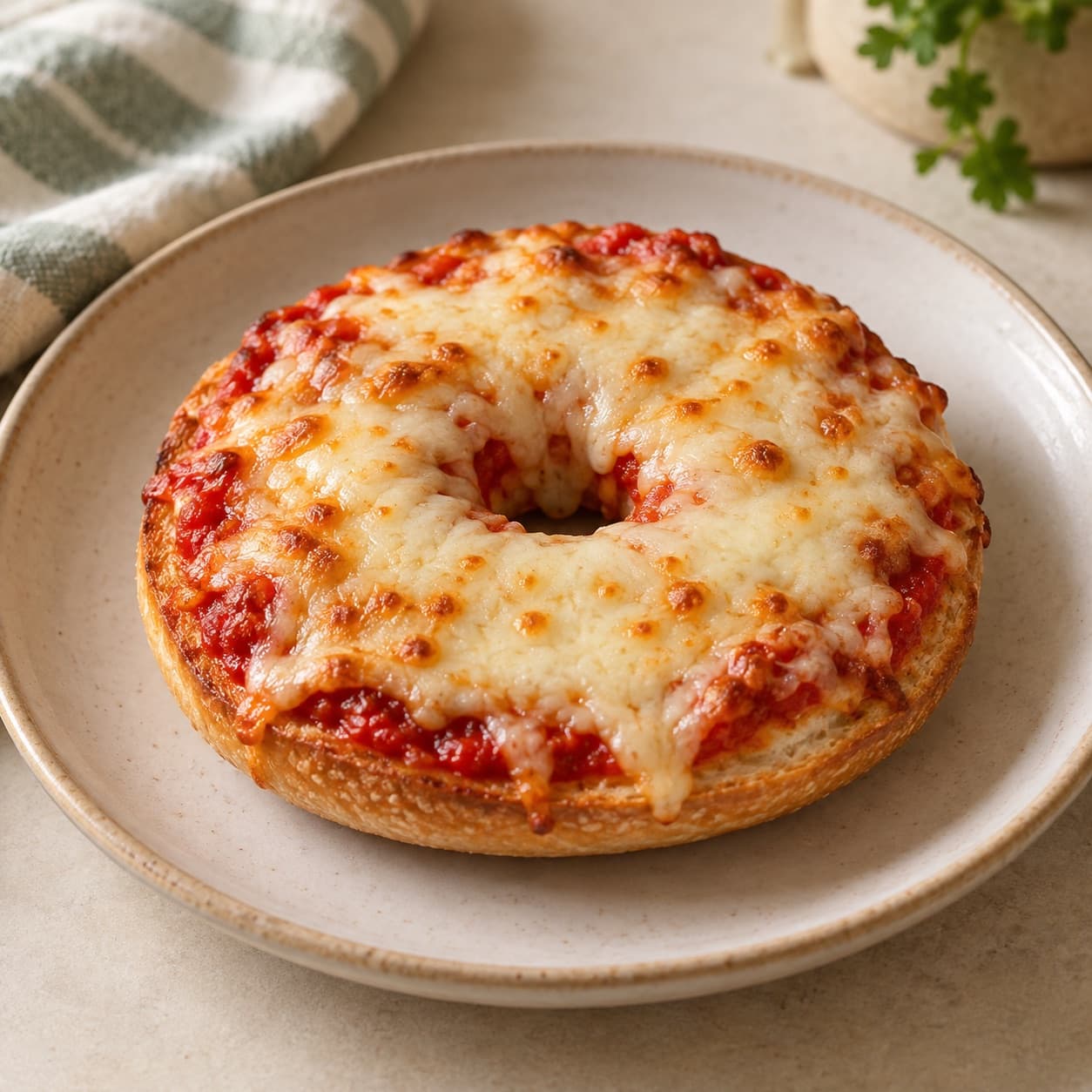 A bagel pizza with tomato sauce and melted cheese